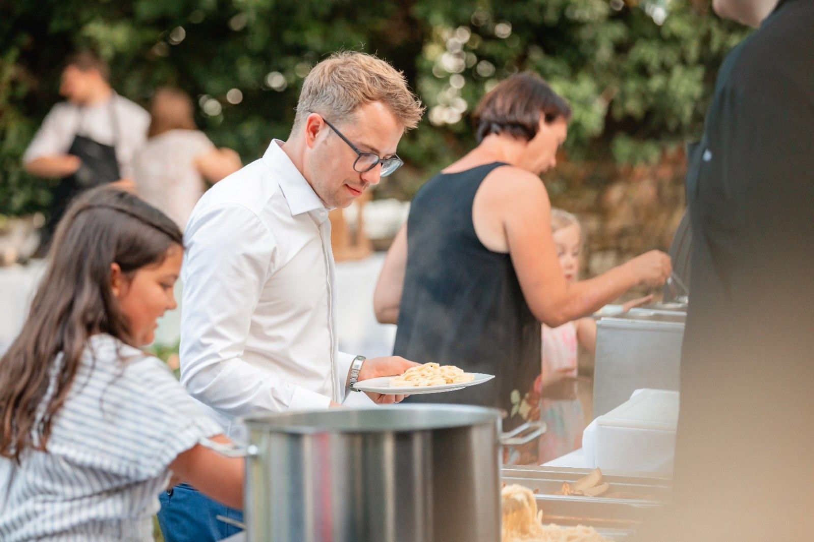 Gäste am Pasta-Buffet im Freien